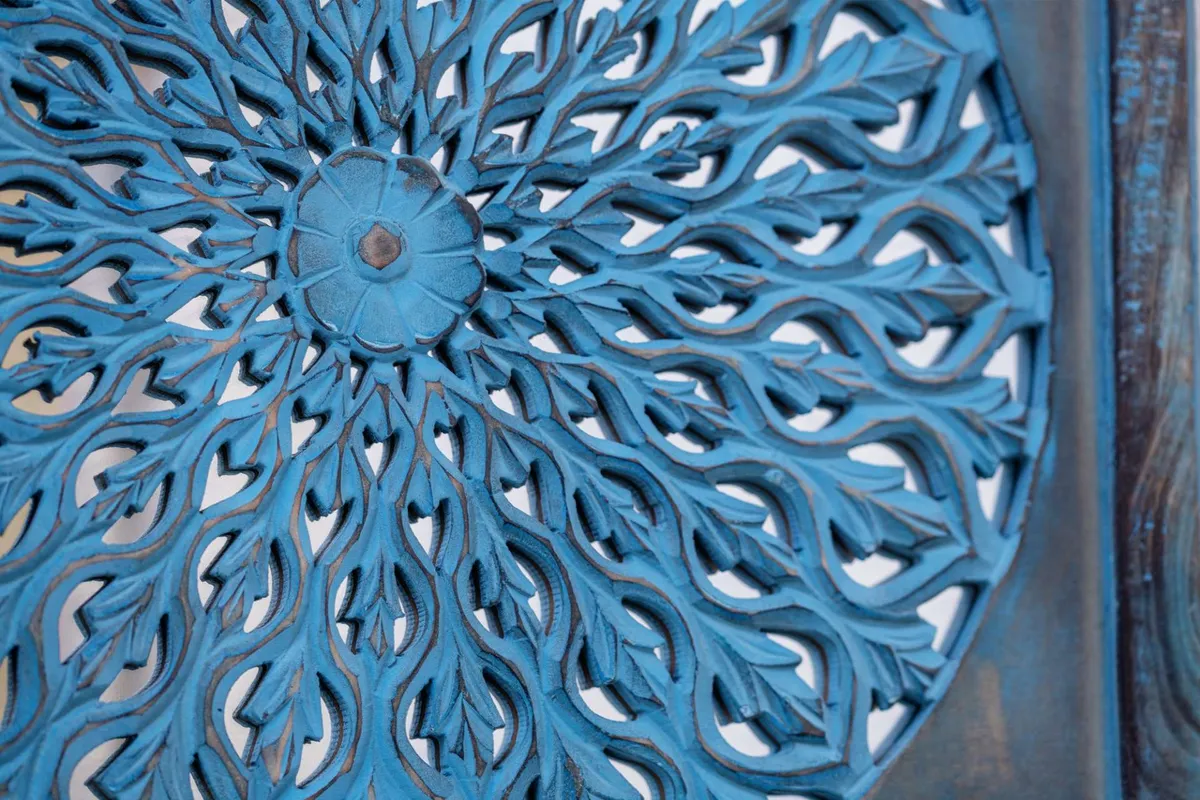 This image features an intricately carved, vibrant blue piece with a symmetrical design, creating an artistic and serene atmosphere. The focus on craftsmanship and detailed decor signals an environment conducive to focus and creativity.