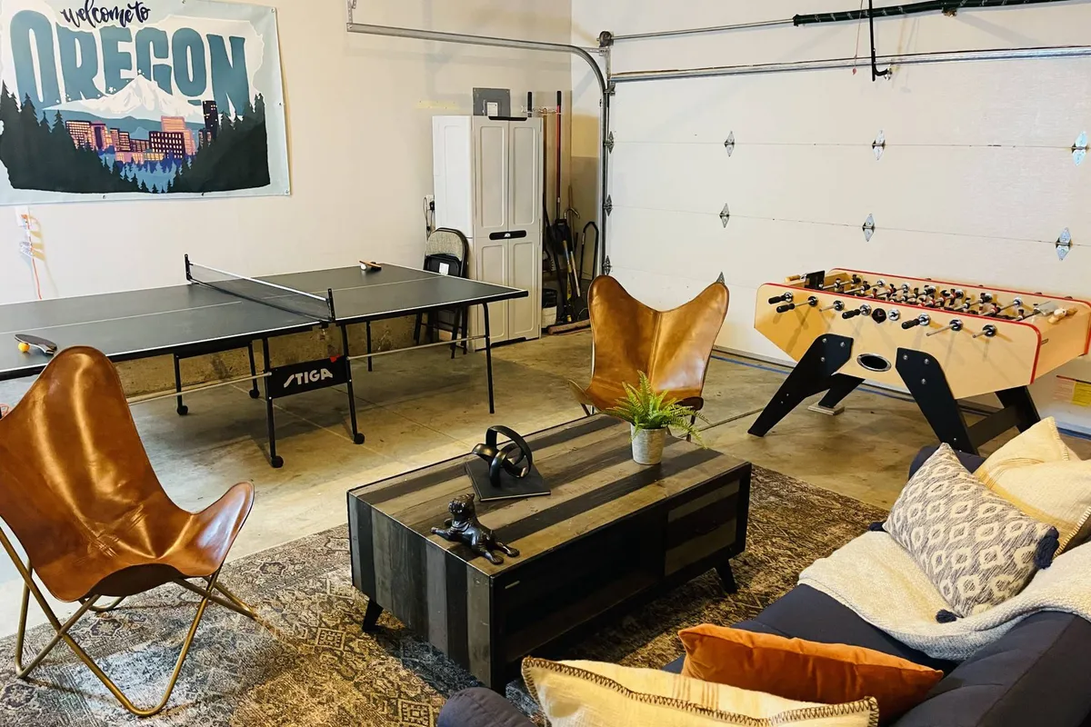 This interior image centers on a ping pong table and foosball table set within a relaxed lounge area, featuring leather chairs and a coffee table. The space is well-lit and arranged for group recreation and socializing, perfectly representing a dedicated game room environment.